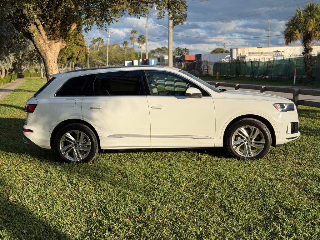 White Audi Q7 parked on the grass at golden hour in Miami